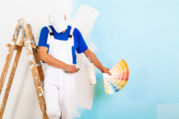 ζωγράφος με paintroller δείχνει μια παλέτα χρωμάτων - Φωτογραφία, εικόνα