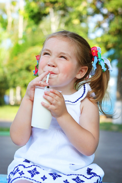 Girl drinking a milkshake through a straw - Фото, зображення