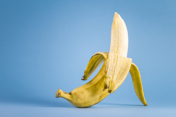 Banán, stojící na modrém pozadí - Fotografie, Obrázek