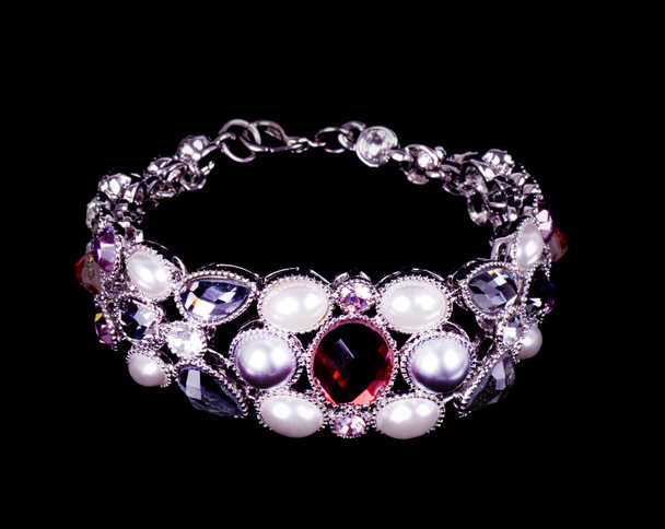 Hermoso brazalete con perlas sobre fondo negro
 - Foto, imagen