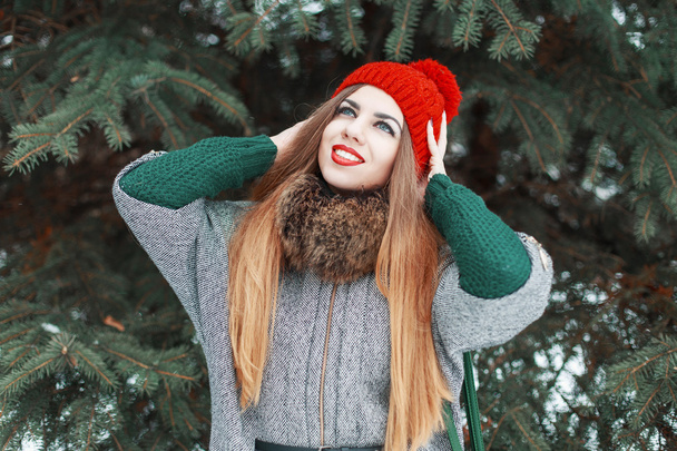 Young beautiful girl with red lips and a knitted hat walks in the park. Good time holidays - Fotografie, Obrázek