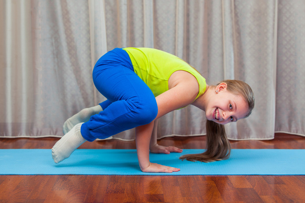 fitness. sport, training and lifestyle concept - Child doing exercises on mat in home. - Foto, immagini