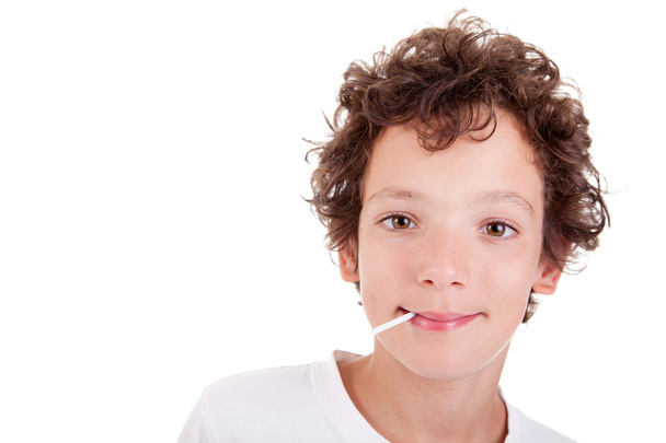 Cute Boy with a candy on mouth smiling, isolated on white, studio shot - Foto, Imagem