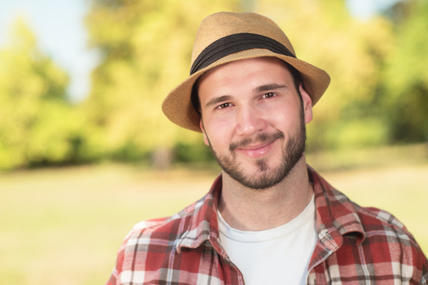 Happy hipster with hat looking at camera on a sunny day - Photo, Image