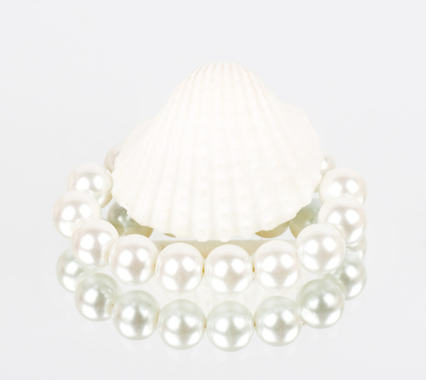 Coque blanche avec collier de perles sur fond blanc
 - Photo, image