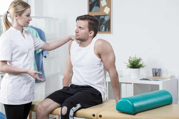 Injured sportsman and young physiotherapist  - Zdjęcie, obraz