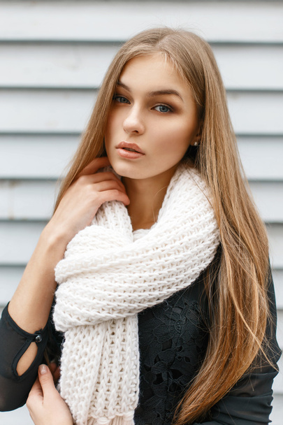 Young beautiful girl in a white knit scarf and a black dress - Foto, imagen