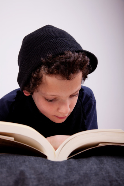 αγόρι που βρίσκεται σε ένα μαξιλάρι ανάγνωση - Φωτογραφία, εικόνα