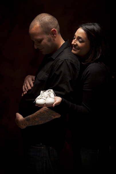 Mischlingspaar mit neuen weißen Babyschuhen auf schwarz - Foto, Bild