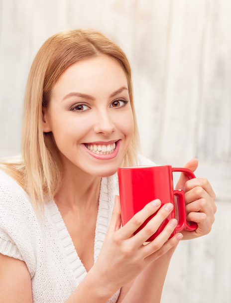 Lady with a cup of tea indoors - Φωτογραφία, εικόνα