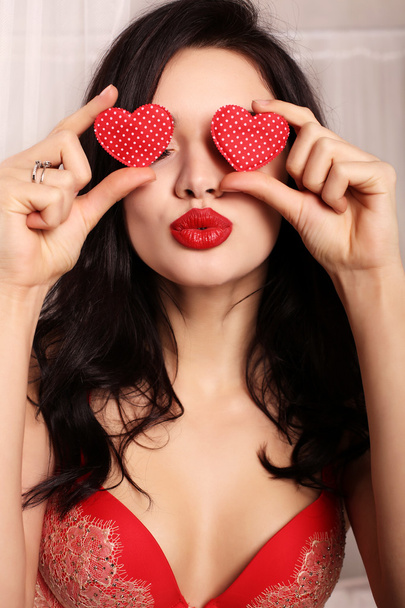 sexy girl in elegant lace lingerie, holding red heart, symbol of Valentine's day   - 写真・画像