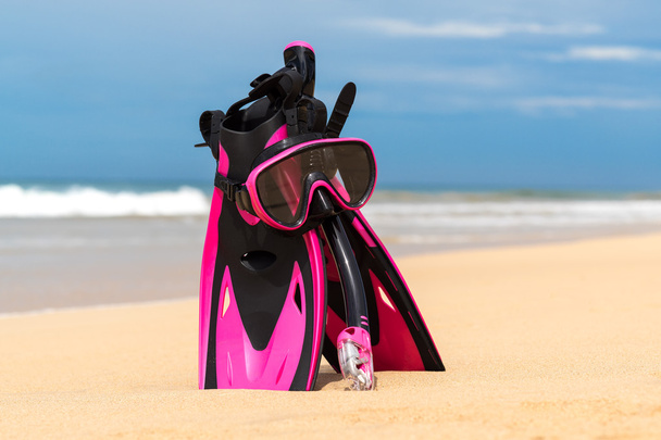Máscara con tubo para snorkel y aletas en la playa
 - Foto, imagen