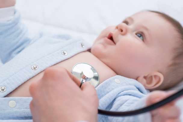 Professional pediatrician examining infant - Фото, изображение