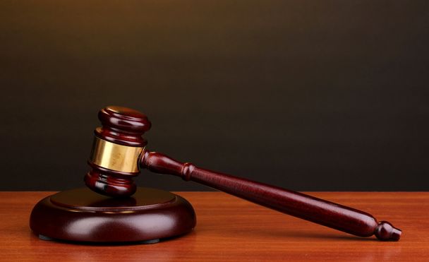 Judge's gavel on wooden table on brown background - Fotó, kép