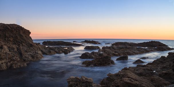 Long exposure of sunset over rocks in Laguna Beach - Photo, Image