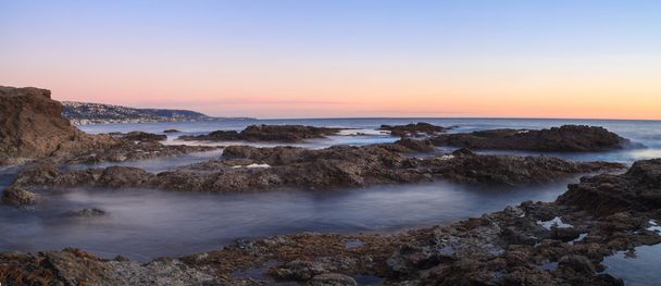 Long exposure of sunset over rocks in Laguna Beach - Photo, Image