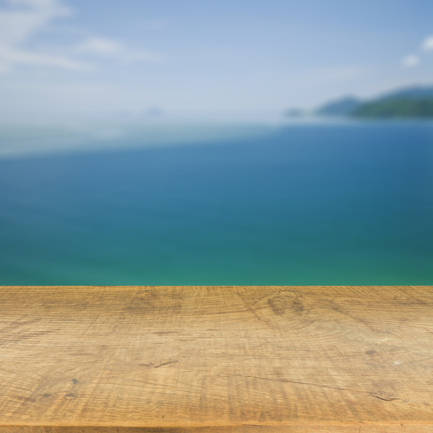 Ahşap masa üstü için kullanılan bulanık mavi deniz arka plan üzerinde ürün görüntüleme - Fotoğraf, Görsel