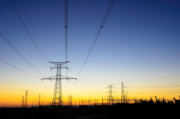 Elektrische elektriciteitsnet over zonsopgang - Foto, afbeelding