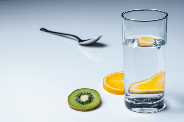 Het glas van water en fruit - Foto, afbeelding