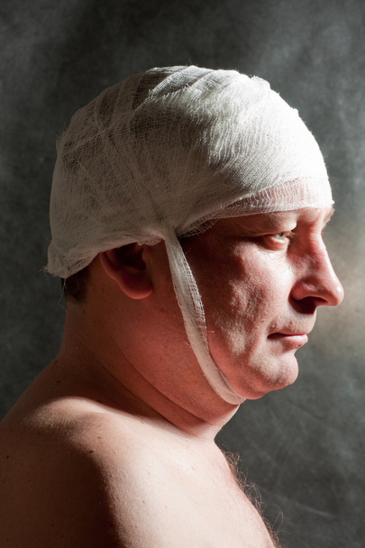 Man with bandage on head. Looking unhappy at something. - Valokuva, kuva