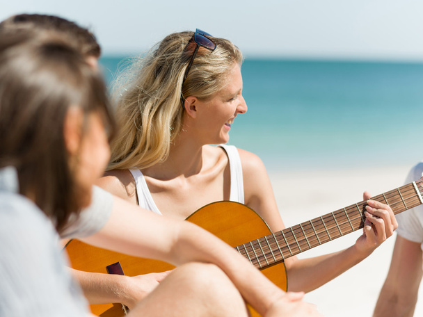 Beautiful young woman playing guitar on beach - Φωτογραφία, εικόνα