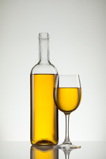 Wine in glass and bottle of wine on white - Фото, зображення