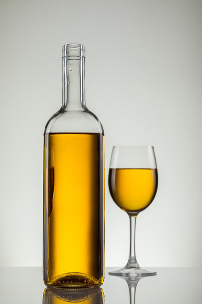 Wine in glass and bottle of wine on white - Foto, Imagen
