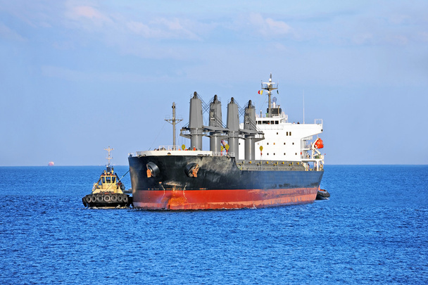 Буксир помогает грузовому судну
 - Фото, изображение