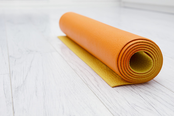 stuoia arancione luminosa di yoga su un laminato grigio chiaro, all'interno
 - Foto, immagini