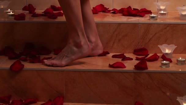 Girl taking bath with rose petals in spa. Dolly crane system. - Кадры, видео