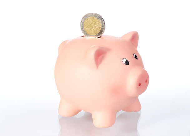 Piggy bank met 2 euromunt voor witte achtergrond - Foto, afbeelding