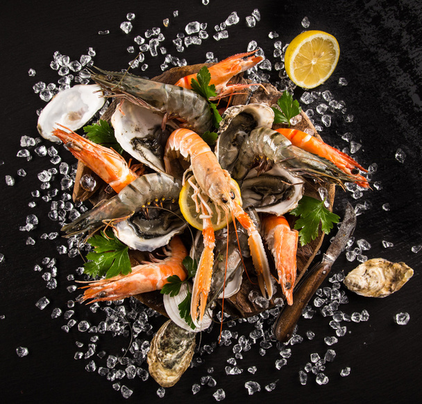 Fresh seafood on black stone. - Photo, image