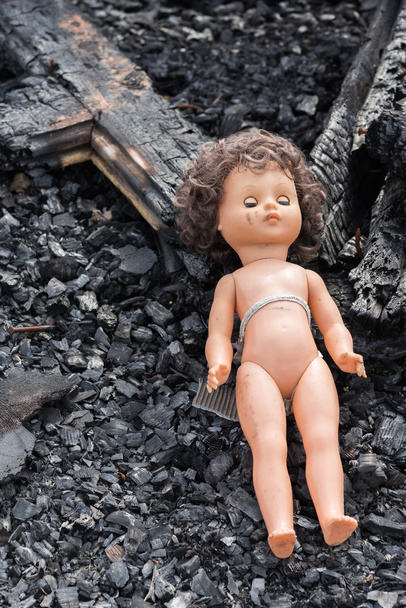 Muñeca de juguete vieja en medio de ruinas y devastación
 - Foto, Imagen