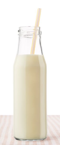 Bottle of milk with straw on checkered tablecloth - Foto, Imagen