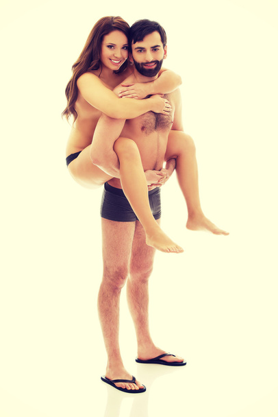 Man carrying girlfriend on his back. - Fotoğraf, Görsel