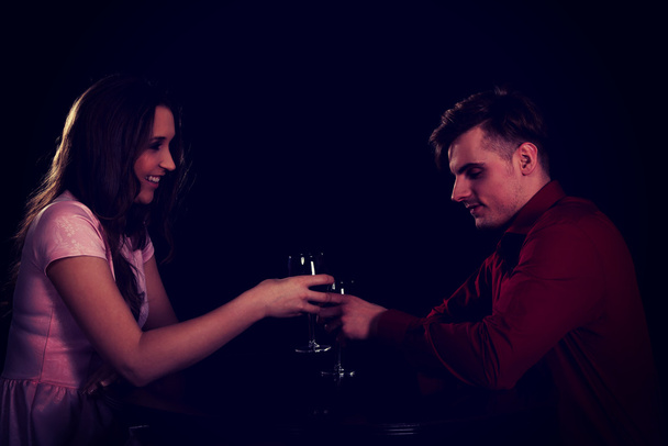 Couple with wine by a table. - Φωτογραφία, εικόνα