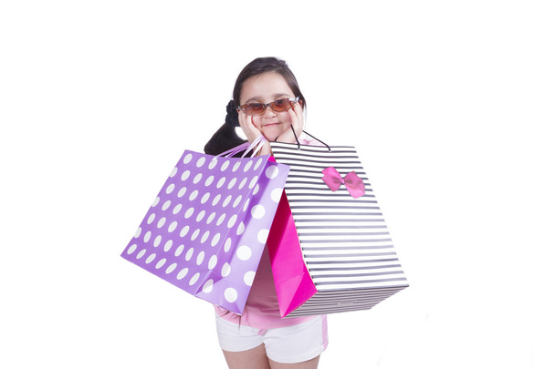 Stylish girl with pink cheeks paper bags holds hands - Photo, Image