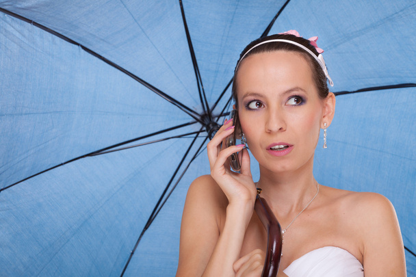Bride woman with umbrella talking on mobile phone. - Fotografie, Obrázek