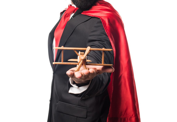 Homme d'affaires super héros tenant un avion jouet en bois
 - Photo, image