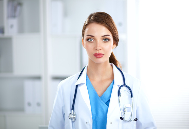 Portrait of young woman doctor with white coat standing in hospital - Photo, Image
