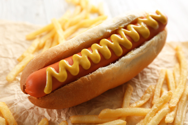 Hot dog and fried potatoes on wooden background - Photo, Image