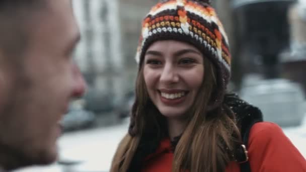 Close-up van een meisje praten met haar nieuwe vriend en glimlachen. Vrouw ontmoet een jongen in de buitenlucht en ze hebben een mooipraterij. - Video