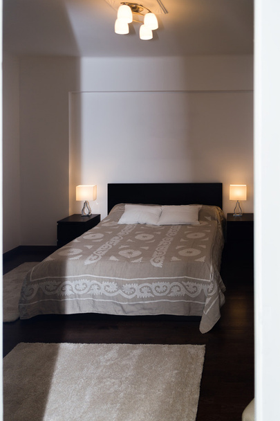 Amplio dormitorio doble moderno de lujo con muebles de madera dura
. - Foto, imagen