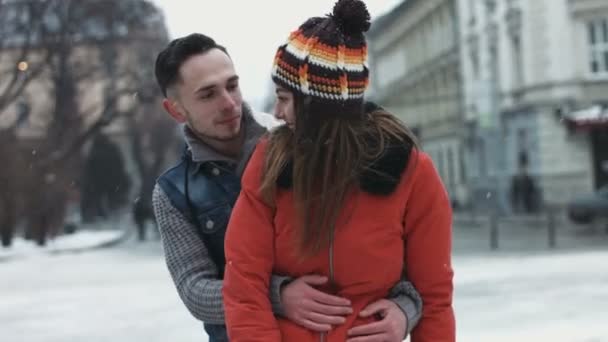 junger Mann versucht, seine Freundin im Freien zu umarmen. glückliches süßes Paar flirtet miteinander. - Filmmaterial, Video