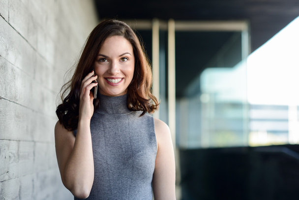 Femme d'affaires parlant avec un smartphone dans un immeuble de bureaux
 - Photo, image
