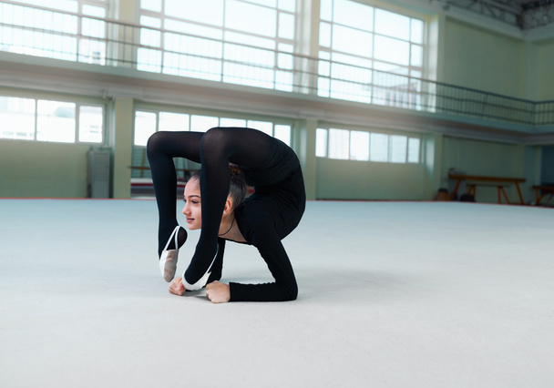 gymnast performs a back bend on  floor - Valokuva, kuva