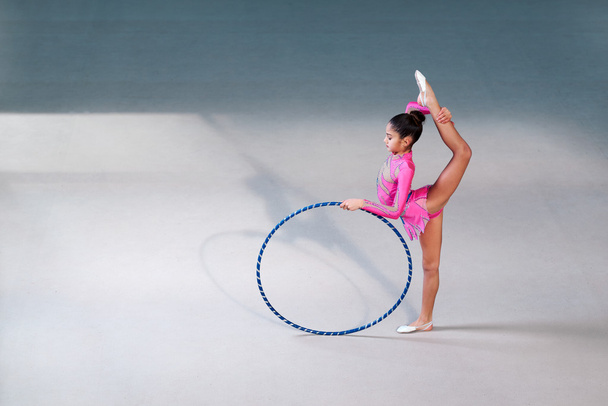 gymnast in a beautiful  suit doing hoop exercise - Фото, изображение