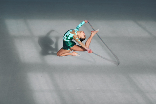 Kaunis voimistelija vihreässä puvussa hyppynaru
 - Valokuva, kuva