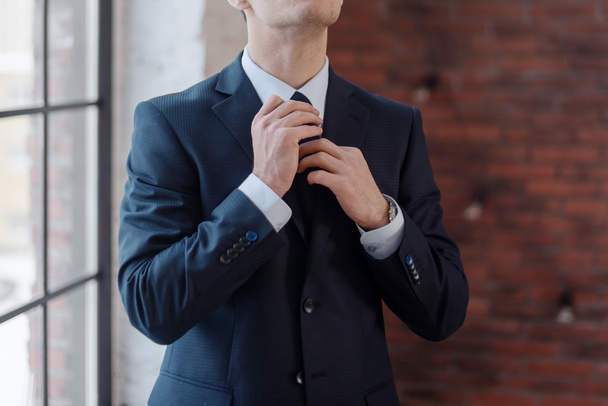 Gros plan de l'homme d'affaires ajustant sa cravate
 - Photo, image