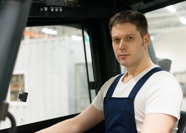 Handsome forklift operator working in the warehouse. - Photo, Image